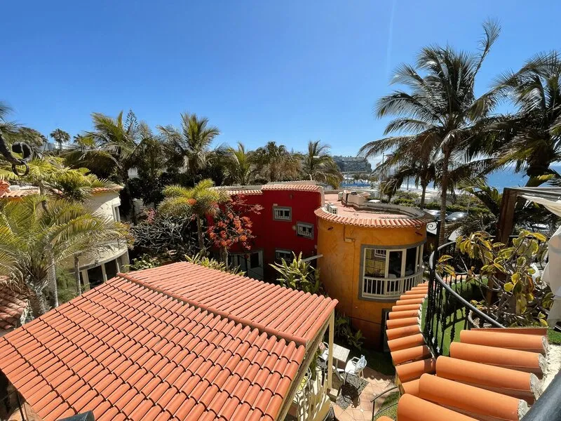 Aussicht von der Dachterrasse des FKK-Resorts Petit Natura über rote Dächer, Palmen und das Meer, Gran Canaria